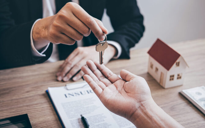 Estate agent giving house keys to client after signing agreement contract real estate with approved mortgage application form, concerning mortgage loan offer for and house insurance.
