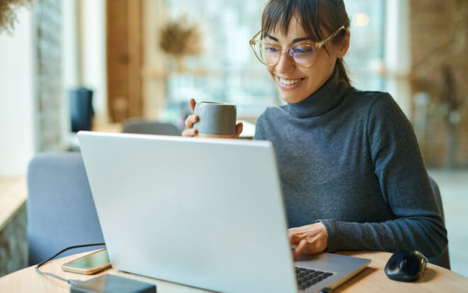 Young smiling business woman in spectacles working on portabl laptop computer.