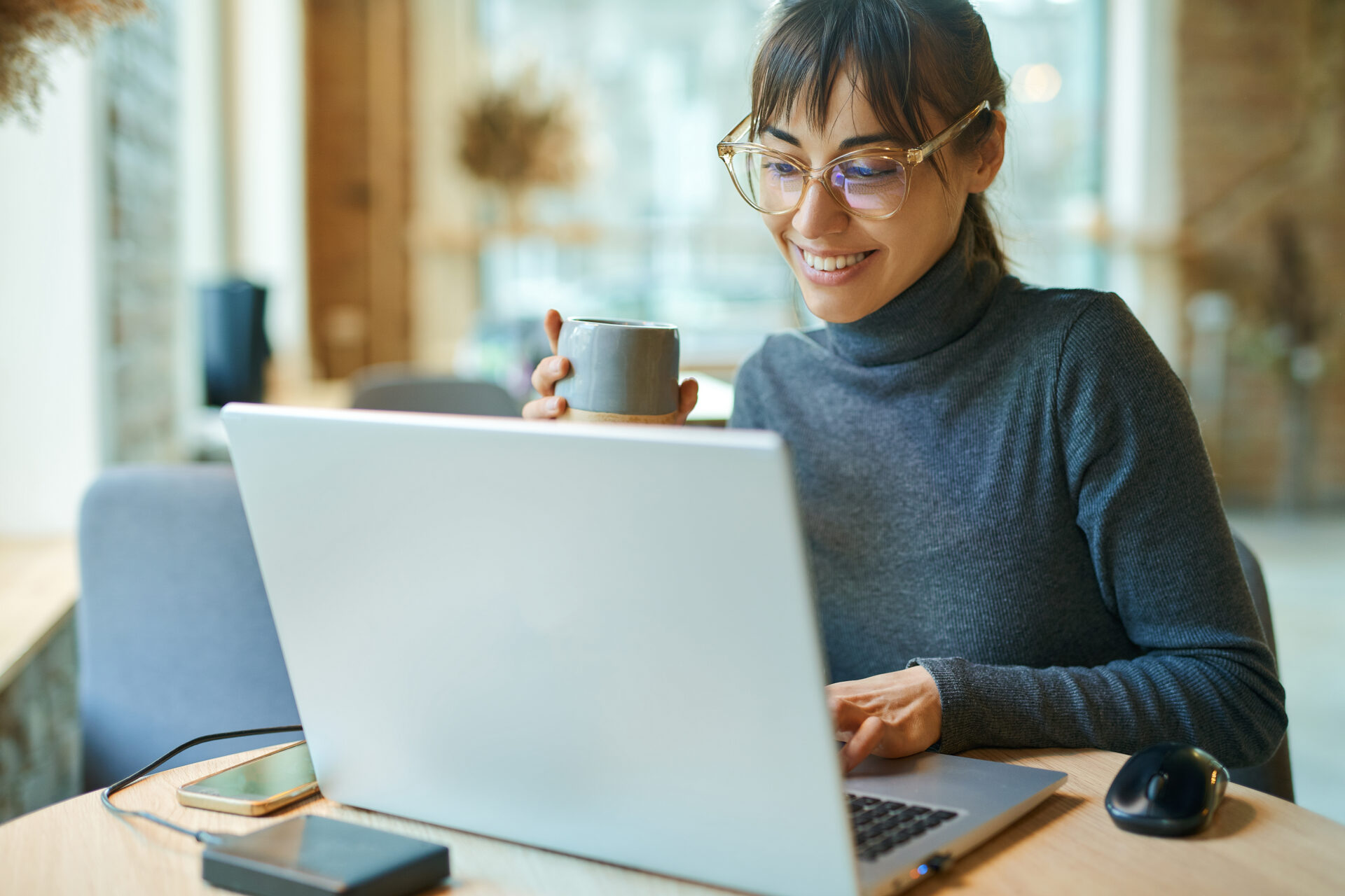 Young smiling business woman in spectacles working on portabl laptop computer.